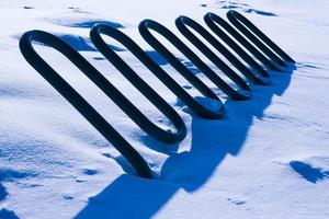 abstraktes wellenförmiges Objekt mit harten blauen Schatten, die mit Schnee bedeckt sind foto