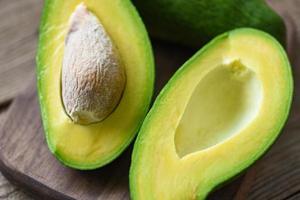 Avocado halbiert auf Holzschneidebrett für Avocadosalat - Obst gesundes Lebensmittelkonzept foto