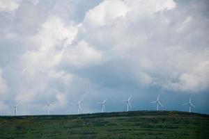 Beeindruckender bewölkter Himmel über einem Hügel mit Windkraftanlagen in einer Reihe. soria, spanien foto