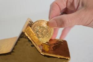 Frauenhand, die ein Bitcoin in einem goldenen Sparschwein mit Sternform einführt foto