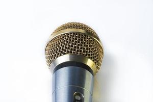 Mikrofon auf weißem Hintergrund mit vergoldeter Düse. foto