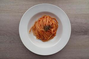 Köstliche italienische Spaghetti mit Tomatensauce auf Holzhintergrund. Sicht von oben. Italien foto