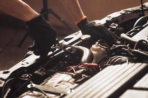 automechaniker repariert auto. Der Mitarbeiter führt die Wartung der Maschine durch. foto