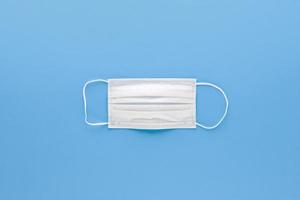 neue saubere weiße medizinische Gesichtsmaske isoliert auf hellblauem Hintergrund Draufsicht foto
