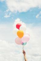Frau Lifestyle-Konzept Frau Hand hält ein paar farbige Luftballons mit blauem Himmel.