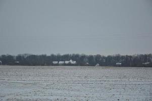 Panorama eines landwirtschaftlichen Feldes, das im Winter mit Schnee bedeckt ist foto