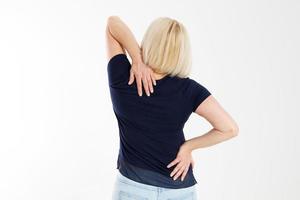 weibliche Rückenschmerzen isoliert auf weißem Hintergrund. frau weibliche rückenschmerzen, rückenschmerzen, weiblicher körper, der schmerzen in der rückenwirbelsäule zeigt. medizinisches konzept, frau mittleren alters, die in weiß steht und den hinteren körper berührt foto