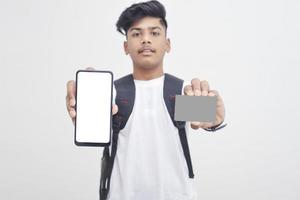 Indischer College-Student, der mobilen Bildschirm und Karte auf weißem Hintergrund zeigt. foto