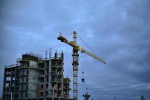 ein Haus in der Stadt und einen Turmdrehkran bauen foto