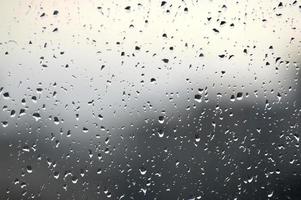 abstrakter Fotohintergrund. Regentropfen am Fenster. selektiver Fokus, regnerischer Stadthintergrund. Wassertropfen auf Glas. Regenwetter, verwischen Tapete foto