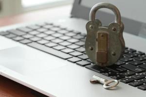 Internet-Sicherheitskonzept - altes Vorhängeschloss und Schlüssel auf der Tastatur des Laptops foto