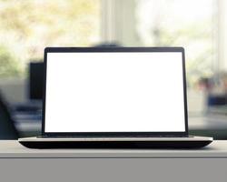 Laptop mit leerem Bildschirm auf weißem Schreibtisch mit unscharfem Hintergrund als Konzept foto