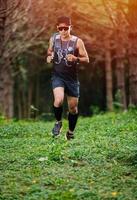 ein mann läufer von trail und athletenfüßen, die sportschuhe für das trailrunning im wald tragen foto