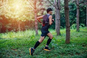 ein mann läufer von trail und athletenfüßen, die sportschuhe für das trailrunning im wald tragen foto