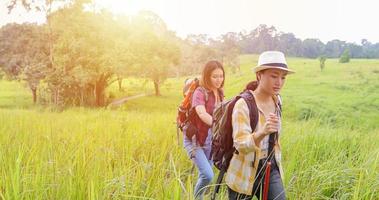 Asiatische Gruppe junger Leute, die mit Freunden wandern, Rucksäcke, die zusammen spazieren gehen und eine Karte suchen und eine Fotokamera an der Straße machen und glücklich aussehen, entspannen Sie sich bei Urlaubskonzeptreisen foto