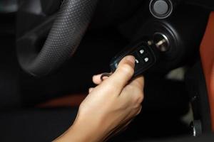 Frauenhände halten den Schlüssel zum Starten des Autos, selektiver Fokus zur Hand foto