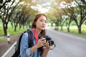 Fotografin, die eine Kamera in freier Wildbahn hält, um ein Foto des Touristenreisenden zu machen