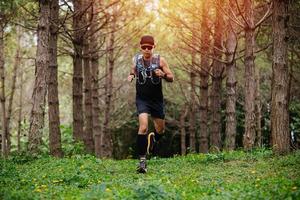 ein mann läufer von trail und athletenfüßen, die sportschuhe für das trailrunning im wald tragen foto