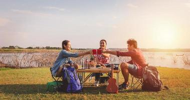 eine gruppe asiatischer freunde, die in den sommerferien kaffee trinken und zeit damit verbringen, ein picknick zu machen. sie sind glücklich und haben spaß an den ferien. foto