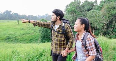 Asiatische Gruppe junger Leute, die mit Freunden wandern, Rucksäcke, die zusammen spazieren gehen und eine Karte suchen und eine Fotokamera an der Straße machen und glücklich aussehen, entspannen Sie sich bei Urlaubskonzeptreisen foto