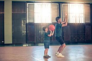 asiatische Familie, die zusammen Basketball spielt. glückliche Familie, die gemeinsam Freizeit im Urlaub verbringt foto