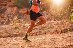 ein Mann Läufer der Spur. und die Füße des Athleten tragen Sportschuhe für Trailrunning in den Bergen, weicher Fokus und verschwommen foto