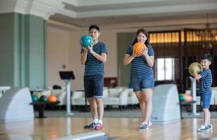 vater unterrichtet sohn und familie spielen bowling im bowling club zur entspannungszeit foto