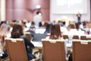 abstrakter, verschwommener hintergrund des seminars der mitarbeiter und des defokussierten teamarbeitspersonals, das sich im konferenzraum mit projektorbildschirm trifft. foto