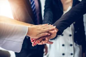 glückliche geschäftsleute, die teamarbeit zeigen und fünf geben, nachdem sie eine vereinbarung oder einen vertrag mit ausländischen partnern im bürointerieur unterzeichnet haben. foto