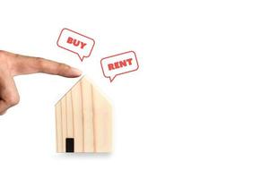 Wahl zwischen Kauf oder Miete. Fingerzeig auf ein kleines Holzhaus mit rotem Pop-up von Kauf- oder Miethaus auf weißem Hintergrund. Unternehmenskonzept. foto