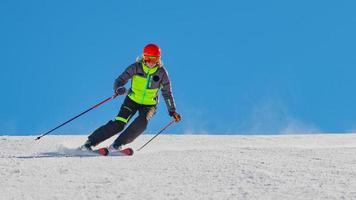 ein Skilehrer beim Skifahren allein in einem Skigebiet foto