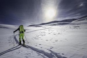 Bergsteiger Skifahrer allein auf einer markierten Piste foto