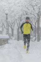 Ein junger Sportler mit Bart bei einem Lauf im Schnee foto