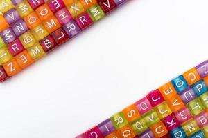 Viele bunte dekorative Würfel mit Buchstaben auf weißem Hintergrund. foto