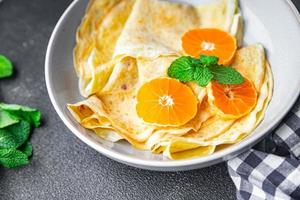 Crêpes Zitrusfrüchte dünne Pfannkuchen süßes Dessert Mandarine oder Mandarinen Frühstück foto