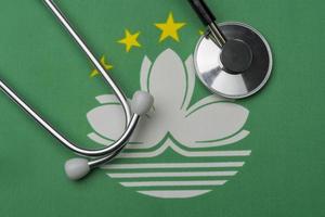 Macau-Flagge und Stethoskop. das Konzept der Medizin. foto