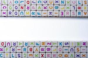 Viele bunte dekorative Würfel mit Buchstaben auf weißem Hintergrund. foto