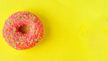 rosa Donut auf pastellgelbem Hintergrund. foto