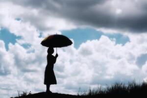 Silhouette einer Frau, die einen sonnigen Tag mit Regenschirm hält foto