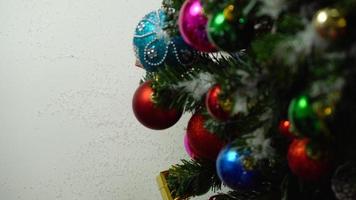 grußsaison concept.hand einstellung von ornamenten auf einem weihnachtsbaum mit dekorativem licht foto