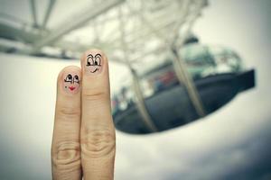 das glückliche fingerpaar, das in gemalten smiley auf londoner stadt verliebt ist, verschwommenen hintergrund foto