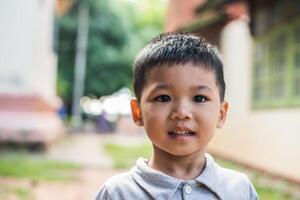 Nahaufnahme Porträt eines asiatischen Jungen, der im Park lächelt. foto