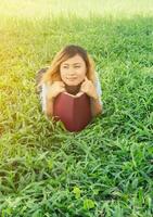 junge schöne hipster-frau liest buch im gras. foto