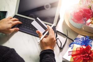 geschenk, das kreative hand mit kreditkarte und hand mit geschenk gibt. geschenklieferung, überraschung, tablet-computer docking smart keyboard auf mable schreibtisch, filterfolieneffekt foto