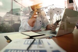 Designer-Handarbeit und Smartphone und Laptop auf Holzschreibtisch im Büro mit Londoner Stadthintergrund foto