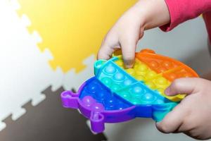 das kind spielt pop it. Mehrfarbiges Bubble Antistress-Spielzeug für Kinder. foto