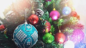 Grußsaison-Konzept. Nahaufnahme von Ornamenten an einem Weihnachtsbaum mit dekorativem Licht foto