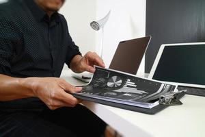 geschäftsmann, der mit smartphone und digitalem tablet und laptop-computer und dokument im modernen büro arbeitet foto