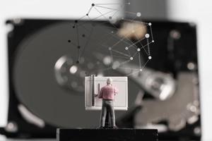 Big-Data-Konzept-Miniaturingenieur, der mit Zeichentisch mit offenem Festplattenhintergrund arbeitet foto