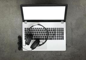 Draufsicht des Arbeitsbereichs zum Komponieren von Musikkonzept mit Kopfhörer und Computer-Laptop auf Textur-Schreibtisch-Hintergrund foto